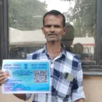 Person holding identification card outdoors.